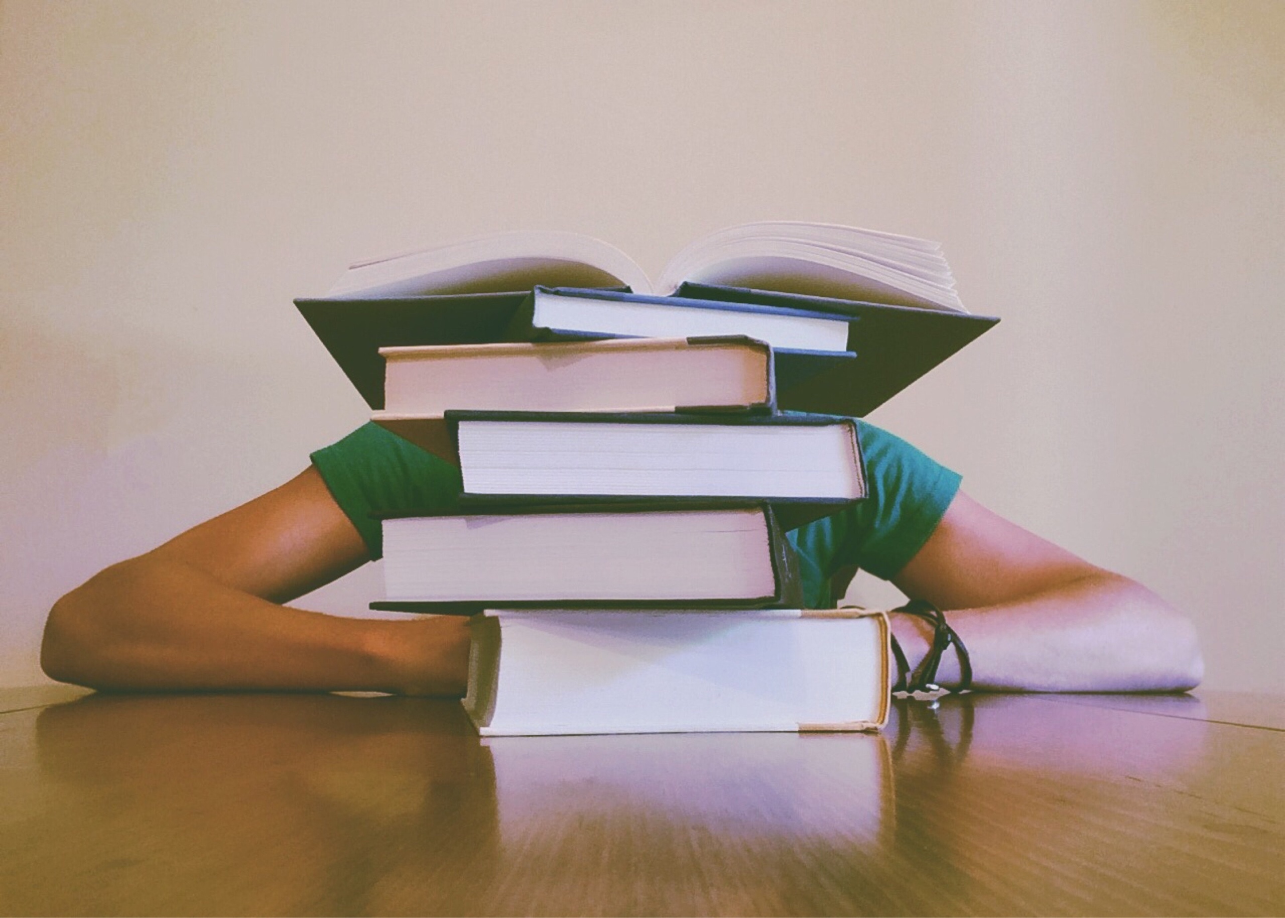 person behind stack of books